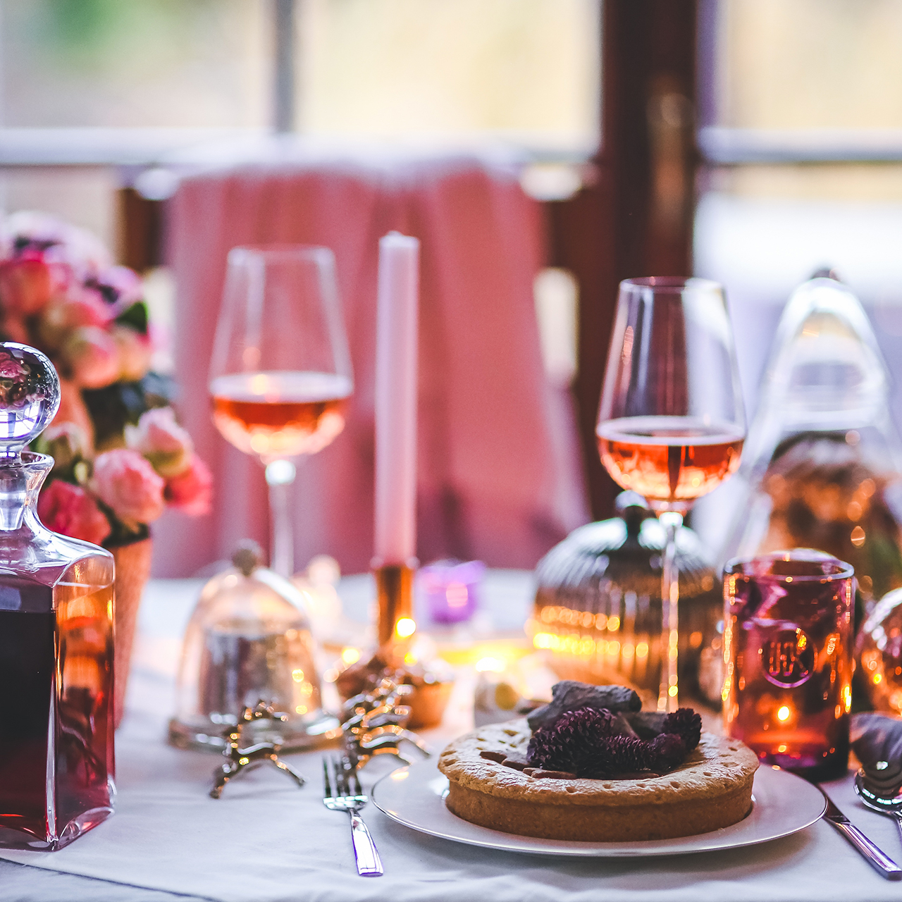 Table élégamment dressée avec verre de vin rosé et tarte en dessert